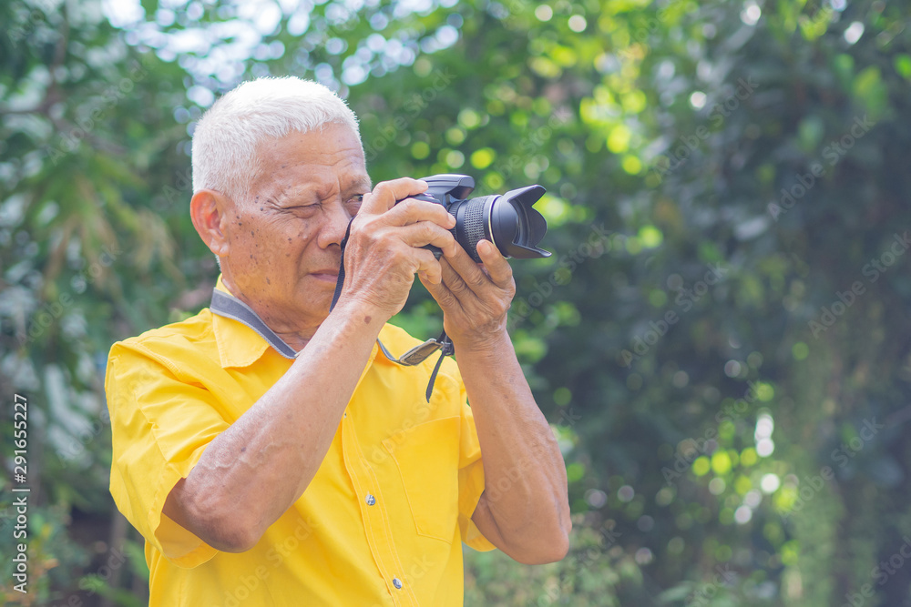 Senior man using a camera to take photo