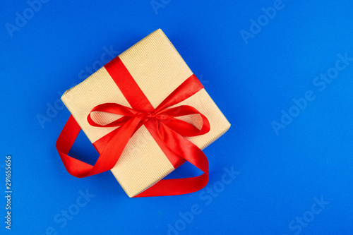 Flat lay of gift box decorated with bow on blue background © fotofabrika