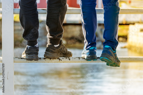 Kids foot standing on a bridge s railing  outdoors  closeup.