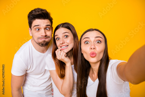 Self-portrait of three nice attractive lovely crazy cheerful cheery positive playful person sending you kiss having fun fooling isolated over bright vivid shine yellow background