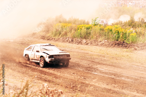 Car on dirt track. Racing cars in the fresh air with dust. One car leads the race  breaks ahead to victory.