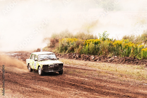 Car on dirt track. Racing cars in the fresh air with dust. One car leads the race, breaks ahead to victory. photo