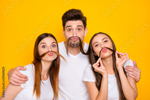 Portrait of cheerful three people with long hairstyle fooling having lips pouted plump wearing white t-shirt isolated over yellow background