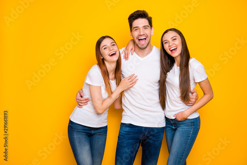 Portrait of cheerful buddies with long ginger foxy hair have fun laugh wear white t-shirt denim jeans isolated over yellow background