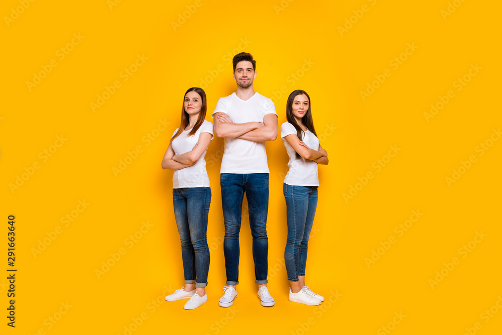 Full body photo of charming people with their arms crossed looking wearing white t-shirt denim jeans isolated over yellow background