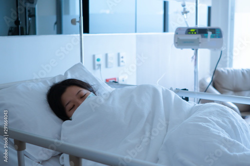 Asian female patient sleeping on hospital bed to recovering sickness  healthcare and medical concept - image