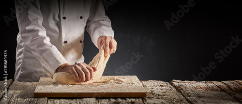 Tela Hands of a male chef, cook or baker kneading dough