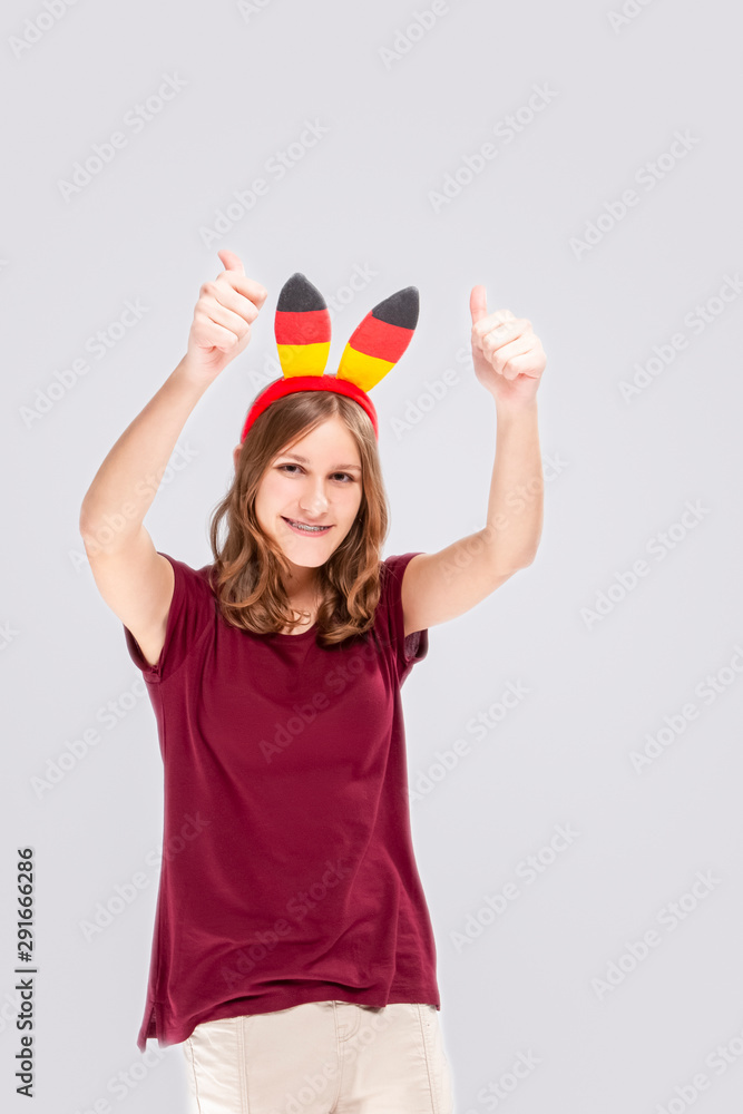 Teenage Lifestyle Concepts. Caucasian teenage Girl Posing With Hoop Demonstrating German Flag. Showing Thumbs Up Sign and Smiling. Teenage Lifestyle Concepts. Caucasian teenage Girl Posing With Hoop Demonstrating German Flag. Showing Thumbs Up Sign and Smiling.
