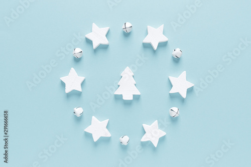 Fototapeta Naklejka Na Ścianę i Meble -  Christmas, New Year or Noel holiday festive winter greeting card with decorations, x-mas fir tree, stars and xmas bells on blue background, flat lay composition, top view, space for text