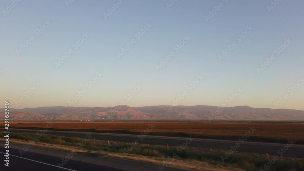 Driving to Los Angeles with mountains in the valley in the distance at sunset Driving to Los Angeles with mountains in the valley in the distance at sunset