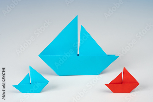 Origami. Concept - Unlike others. Ships made of paper in different colors. Another color as a metaphor is another way of development. Selection of a candidate for the position. Diversity of choice.