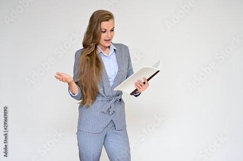 Portrait of a beautiful manager girl in a gray business suit on a white background with a folder in her hands. Stands in different poses with emotions.