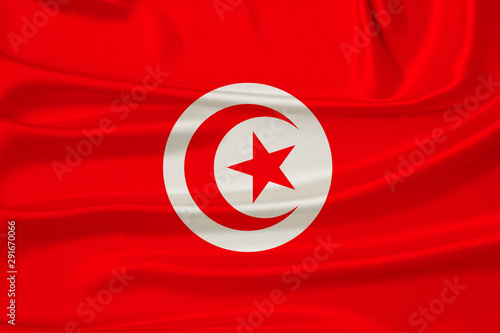 beautiful photo of the national flag of Tunisia on delicate shiny silk with soft draperies, the concept of state power, country life, horizontal, close-up, copy space