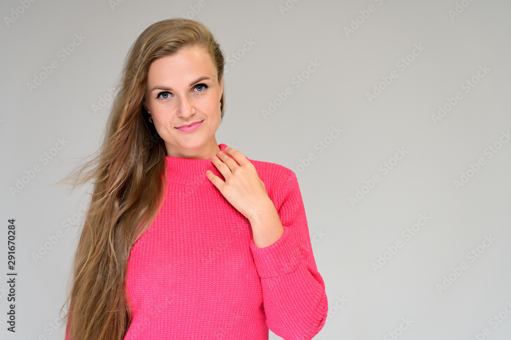Φωτογραφία Close-up portrait of a beautiful girl with long hair in a coral sweater on a white background