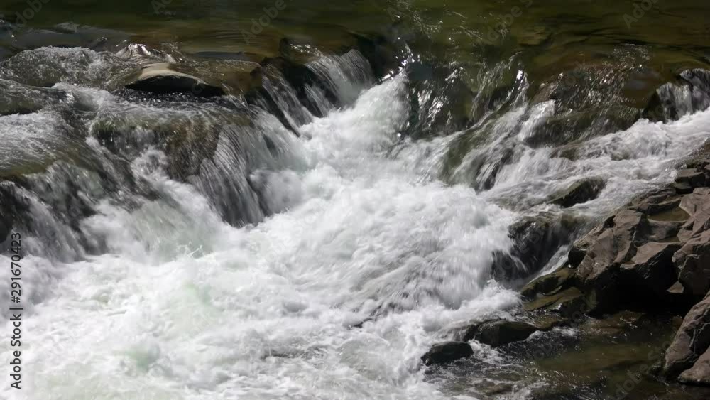 Fast mountain stream on a summer day. Water flow over rocks. Fast mountain stream on a summer day. Water flow over rocks.