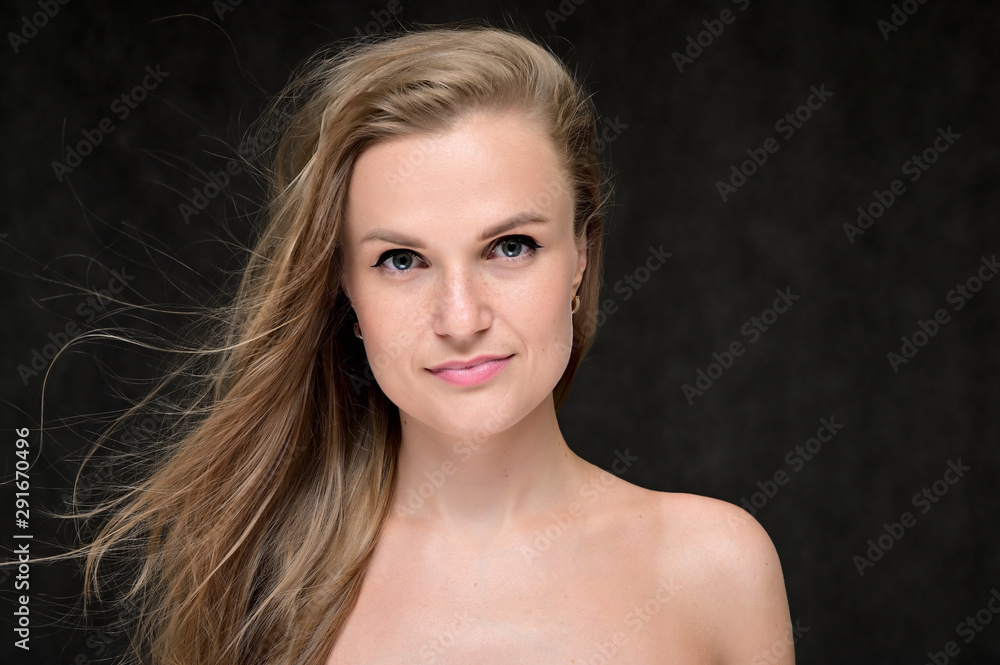 Close-up portrait of a beautiful girl with long hair and excellent skin on a gray background. Close-up portrait of a beautiful girl with long hair and excellent skin on a gray background.