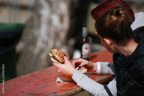 Woman is holding a burger in her hand.. photo