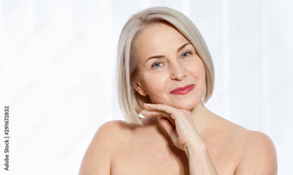 Fifty year old woman is very pleased with her wellgroomed face