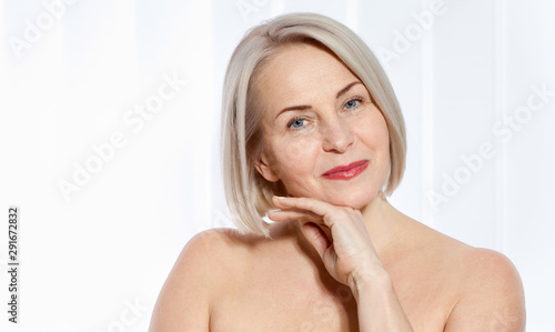 Cuadro en lienzo Fifty year old woman is very pleased with her well-groomed face