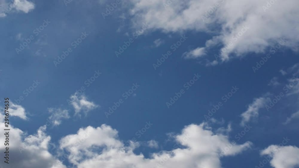 White and Dark Cumulus Clouds Flowing Fast in Blue Sky.