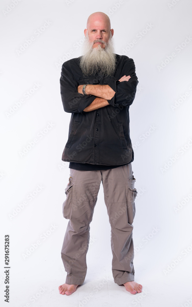 Full body shot of mature bald bearded man with arms crossed Full body shot of mature bald bearded man with arms crossed