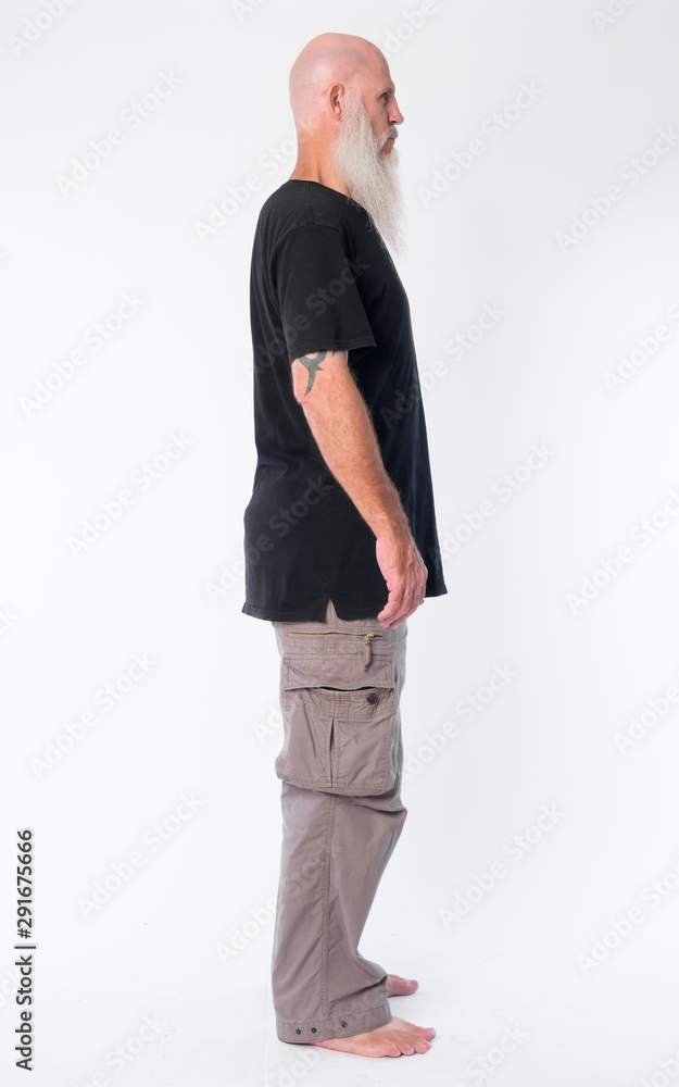 Full body shot profile view of mature bald man with long gray beard Full body shot profile view of mature bald man with long gray beard