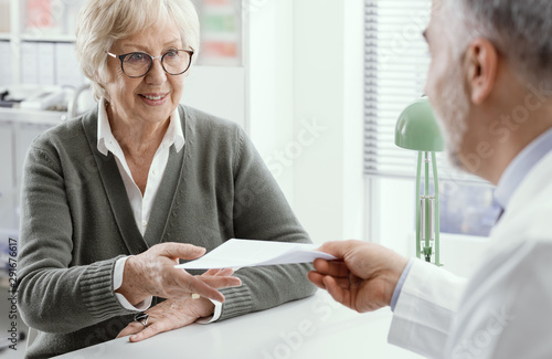 Wallpaper Mural Professional doctor giving a prescription to a senior patient Torontodigital.ca