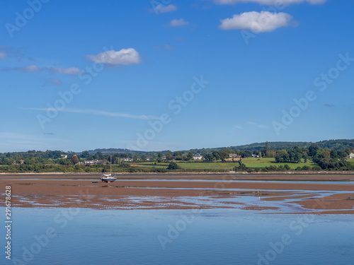 Obraz na plátně Sunny day view of the river Exe estuary at Exmouth, with unidentifiable boat grounded on sandbank