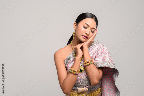 The girl wears Thai dress and hands touch the face.