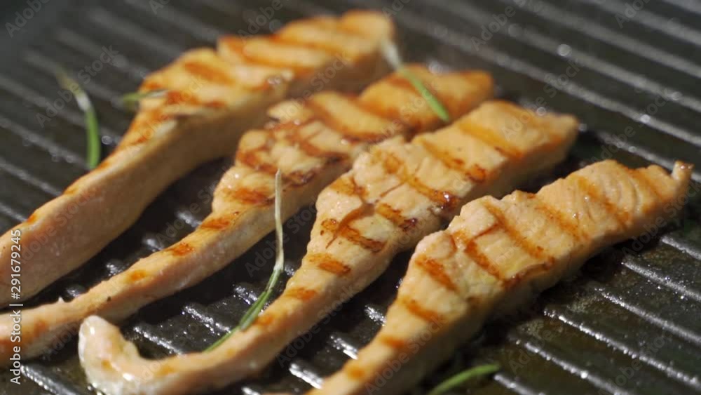 Piece of salmon or trout fillet frying on grilled pan. Piece of salmon or trout fillet frying on grilled pan.