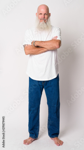 Full body shot of mature bald bearded man with arms crossed