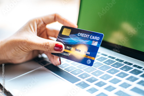 Foto woman sat with a laptop and paid with a credit card