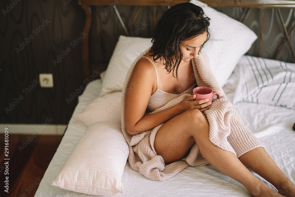 Young woman drinking morning coffee in bed Young woman drinking morning coffee in bed