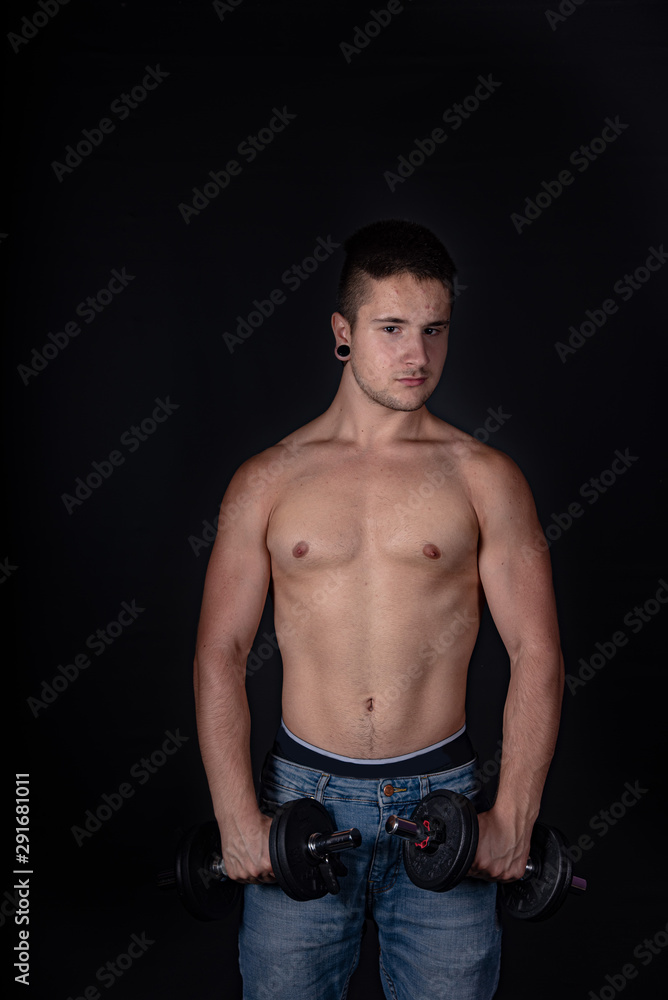 Fototapeta premium Chico fitness gimnasio training pesas fondo negro