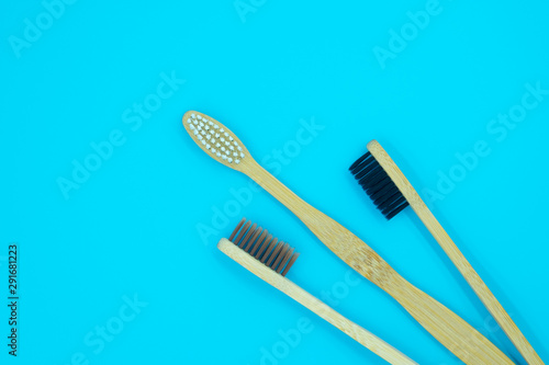 Wooden bamboo toothbrushes isolated on blue background. Concept dental eco-friendly...