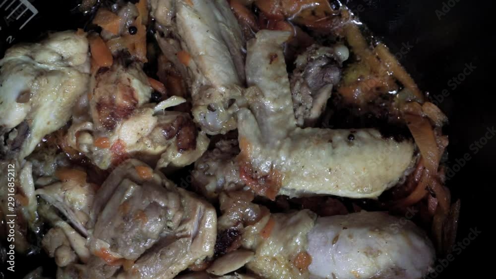 Adding potato to frying chicken thighs. Overhead shot Adding potato to frying chicken thighs. Overhead shot