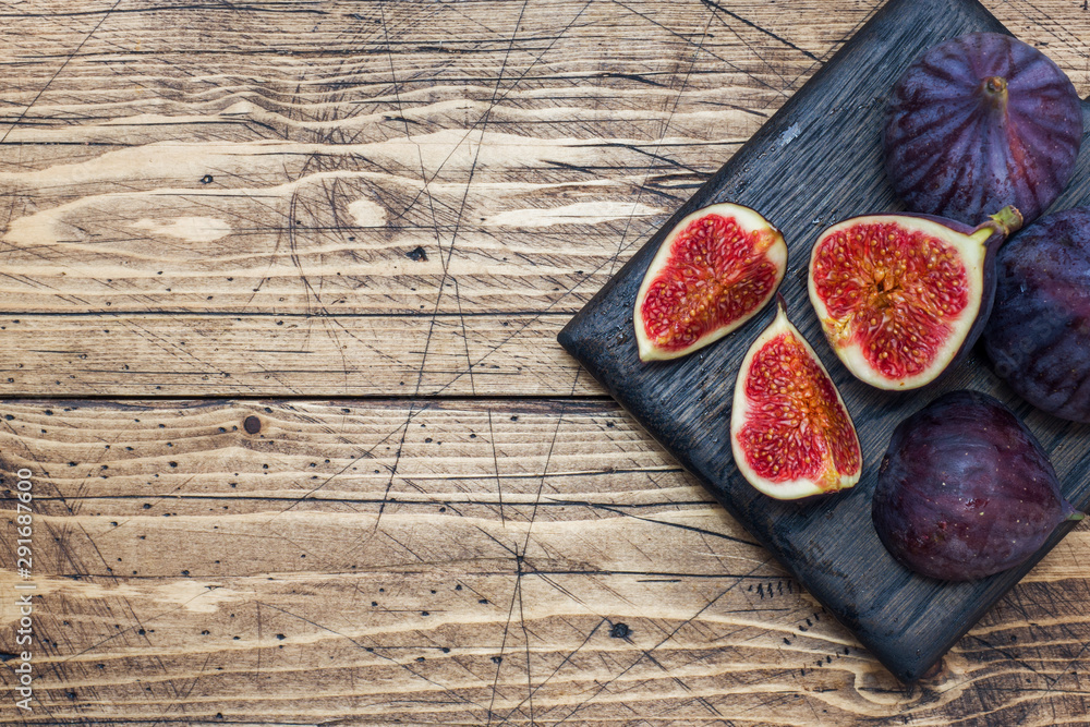 Ripe figs whole and cut on a wooden cutting Board. Selective focus.Copy space.