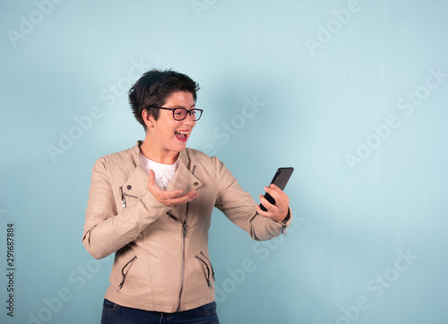 Woman take photo smartphoe selfie blue background 