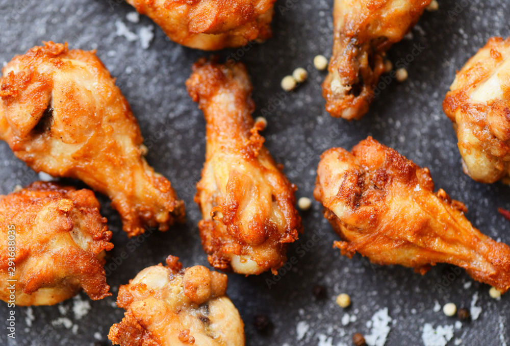 Fried chicken wings on black plate with salt herbs and spices , top view - Baked chicken wings BBQ , wings crispy