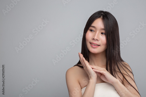 Women wear white strapless tops and put their left hands on their right hands.