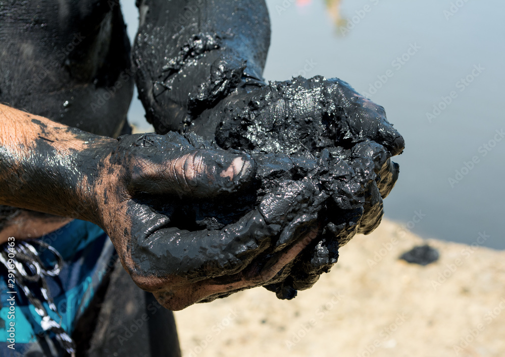 Man applying black healing clay Man applying black healing clay