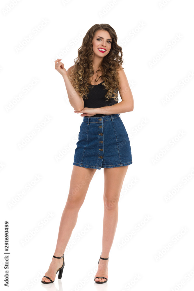 Young Sexy Woman In Jeans Mini Skirt, Black Top And High Heels. Young Sexy Woman In Jeans Mini Skirt, Black Top And High Heels.