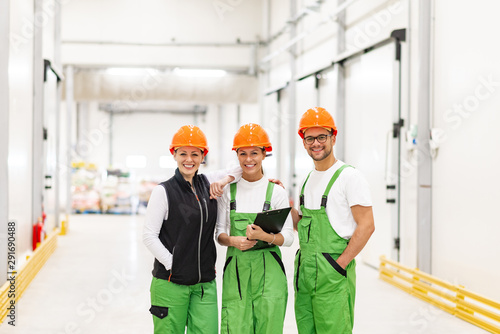 Portrait of a young workers at food factory, smiling at camera.