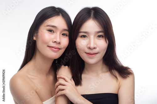 Two young women happily stood together from behind.