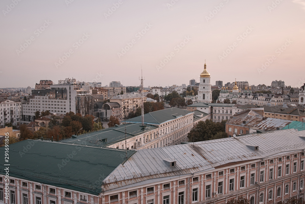 Obraz premium View overlooking the town. Kiev view into the distance to the city. Houses and buildings. Roofs of buildings. Cathedral in the city center. Streets, roof, houses, structures, a trip to Europe