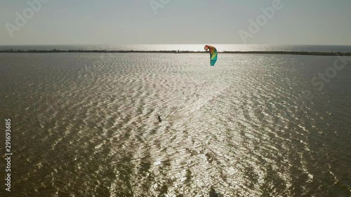 Kitesurfers ride on waves in the summer on the sea in windy weather