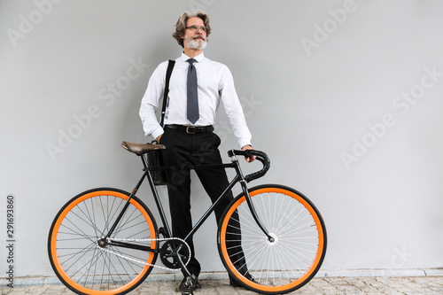 Fototapeta Naklejka Na Ścianę i Meble -  Photo of modern elderly businessman standing with bicycle