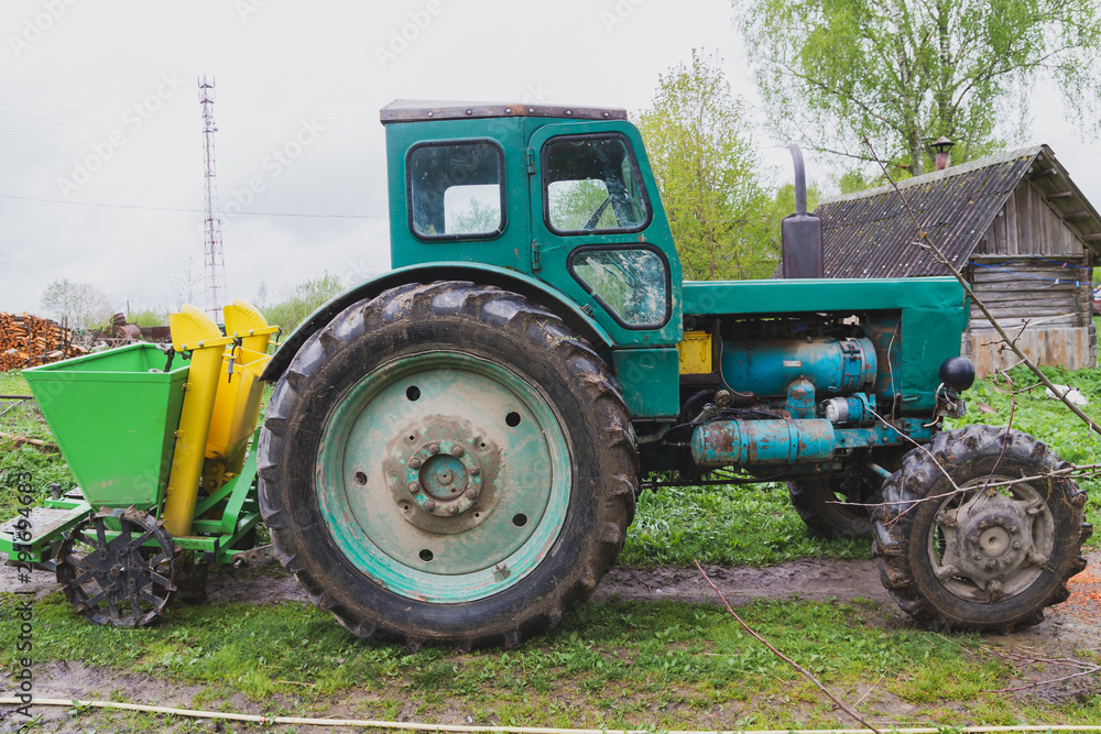 Old tractor in the village in early spring Old tractor in the village in early spring