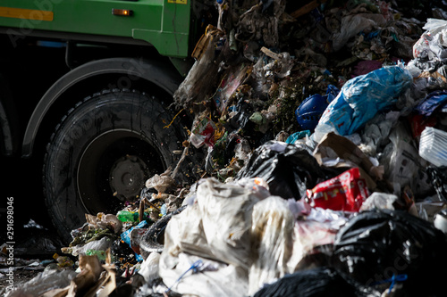 Truck tipping garbage from container on junk yard