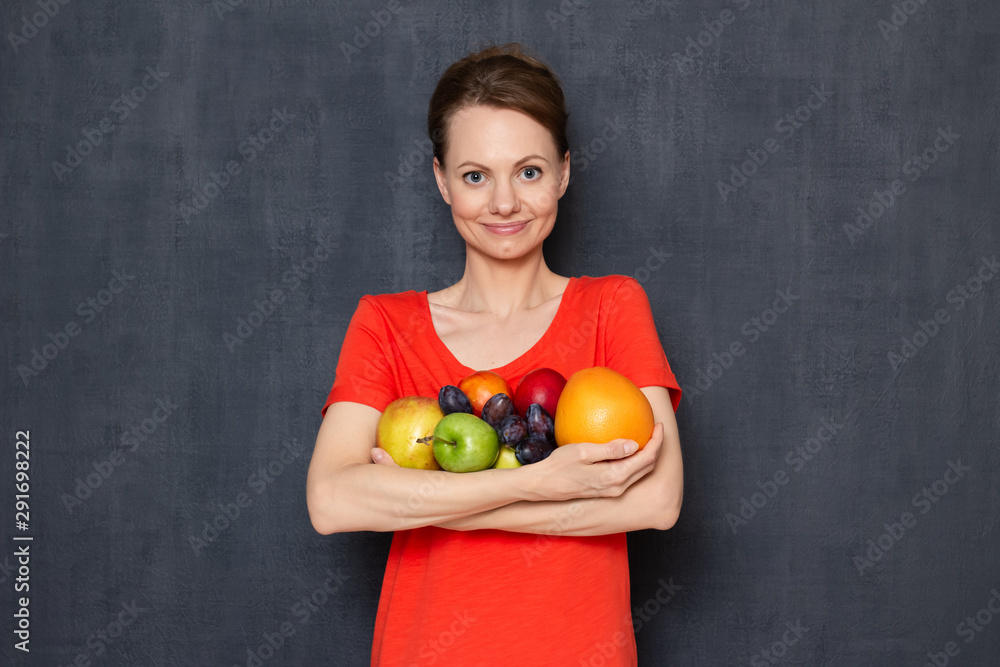 Portrait of happy young woman holding ripe fresh fruits in hands Portrait of happy young woman holding ripe fresh fruits in hands